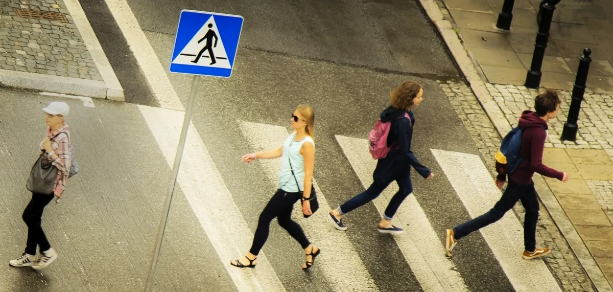 Overhead view of four pedestrians crossing a zebra crossing in different directions